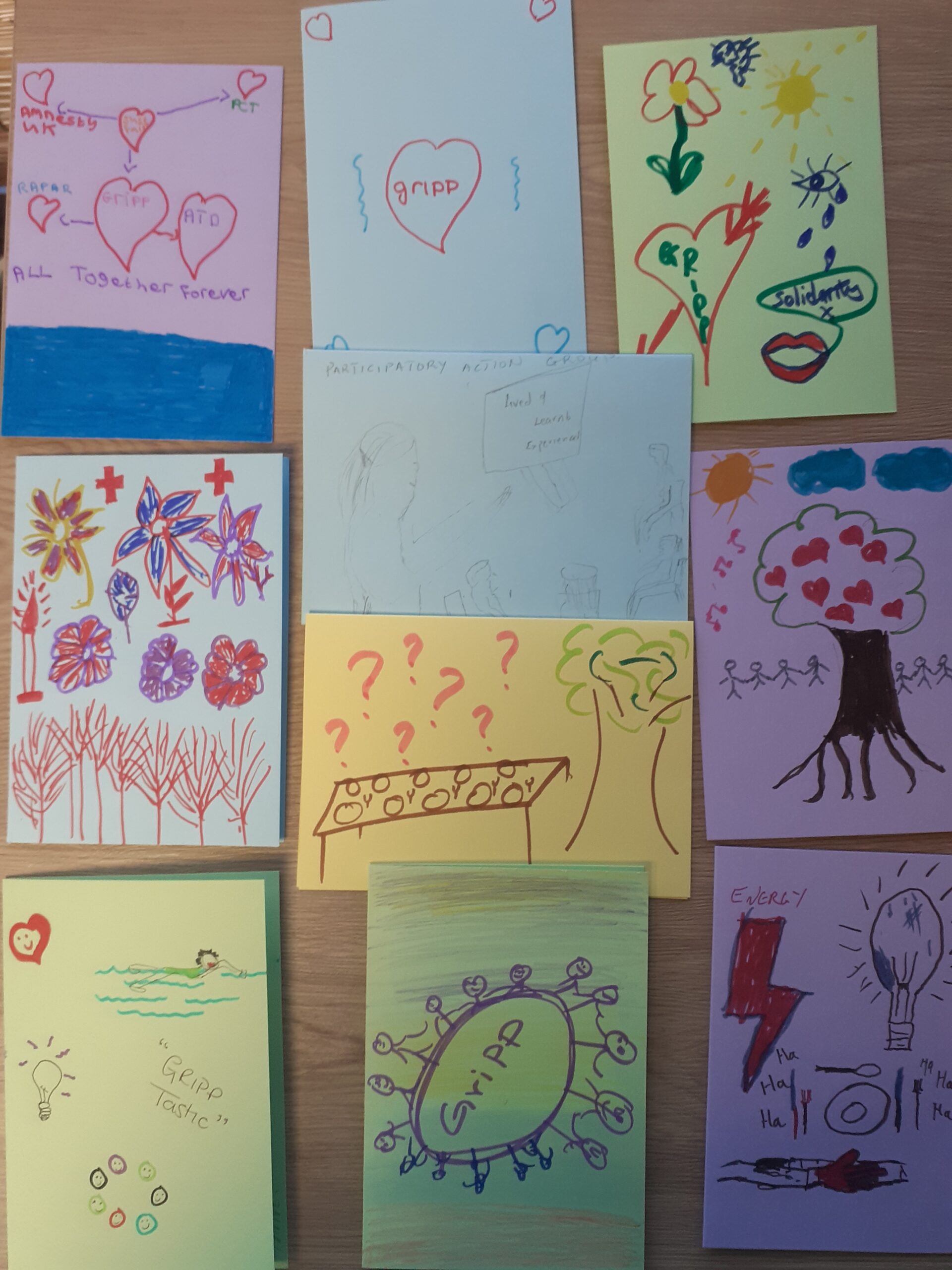 9 hand drawn postcards on various colours - hearts, flowers, a long dinning table, trees, light bulbs, lots of people, capture participants key memories of the residential